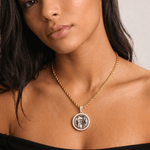 Female model wearing CRNCY's Double Sided Photo Necklace with a 14k gold finish and a 18 inch length necklace.
