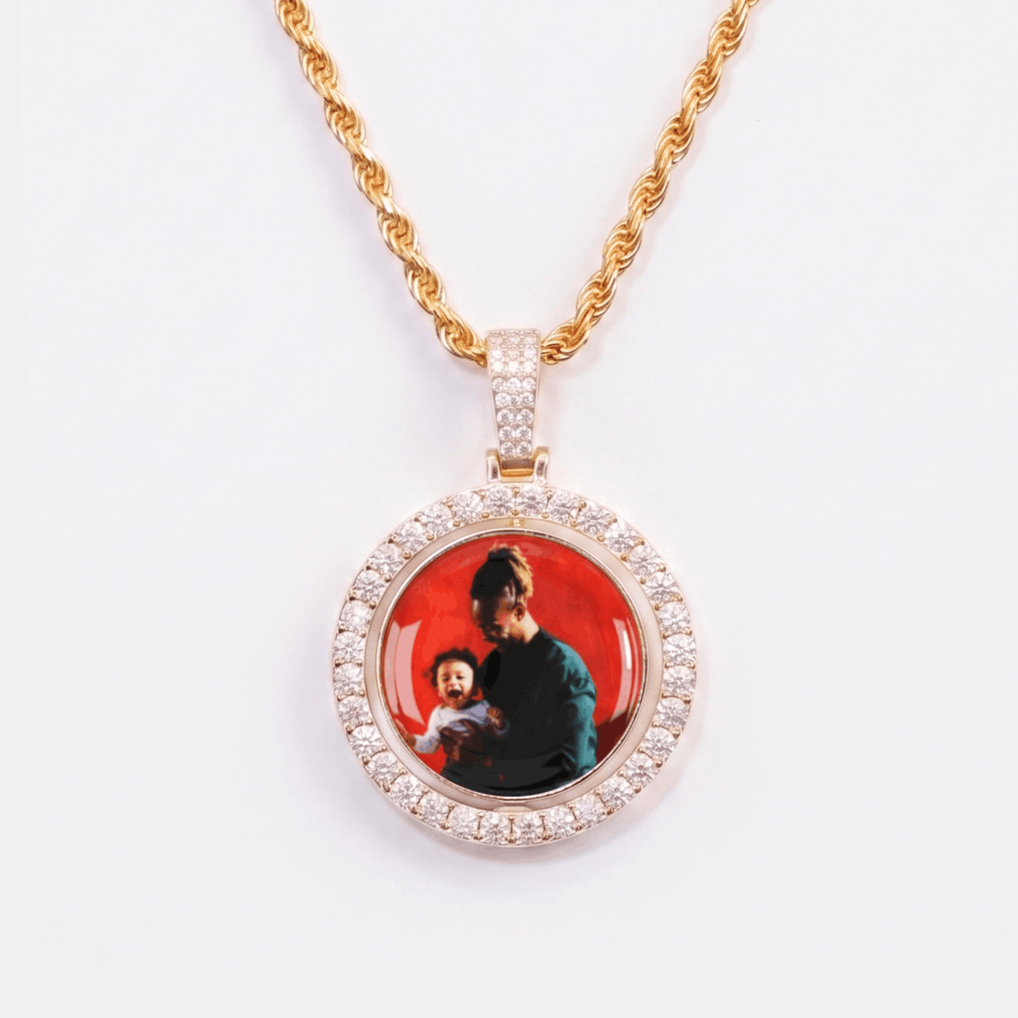 The front side of CRNCY's Double Sided Photo Pendant with a 14k gold finish. The front side features prong-set diamonds around the photo and on the bale. The front side shows the first photo choice.