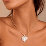Female model wearing CRNCY's Mom Heart Photo Pendant with a 14k gold finish and a 16 inch length necklace.