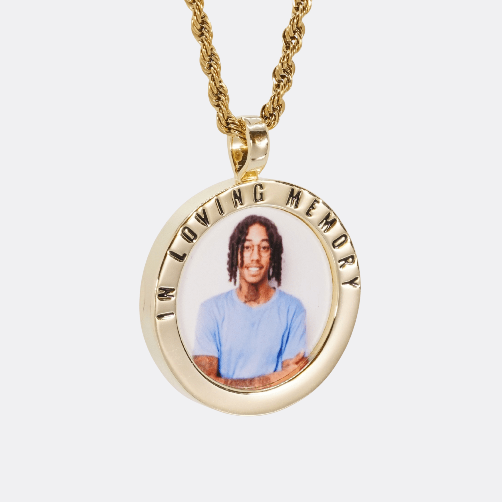 The front side of CRNCY's In Loving Memory Photo Pendant with a 14k gold finish. The front side features a polished border around the photo. "In Loving Memory" is engraved on the upper half of the photo pendant, filled with black jewelry enamel. The front side shows the customer's photo selection. 
