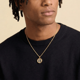 Male model wearing CRNCY's Mini Photo Pendant with a 14k Gold Finish, with a 20 inch length necklace.