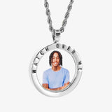 The front side of CRNCY's Watch Over Me Photo Pendant with a silver finish. The front side features a polished border around the photo. "Watch Over Me" is engraved on the upper half of the photo pendant, filled with black jewelry enamel. The front side shows the customer's photo selection. 
