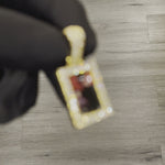 Close-up video of the details of CRNCY's Small Framed Photo Pendant, with a 14k gold finish.