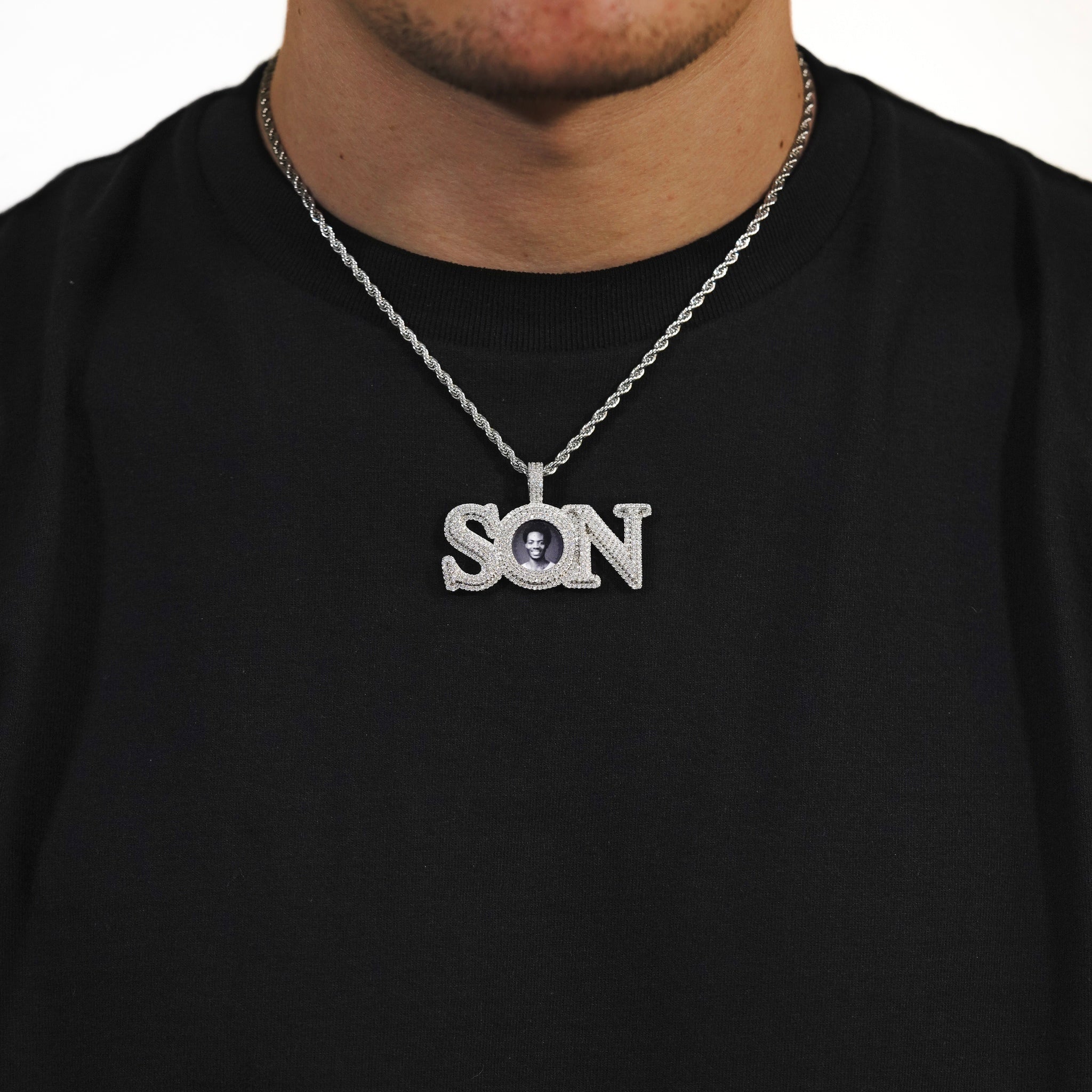 Male model wearing CRNCY's SON Photo Pendant with a silver finish and a 18 inch length necklace.