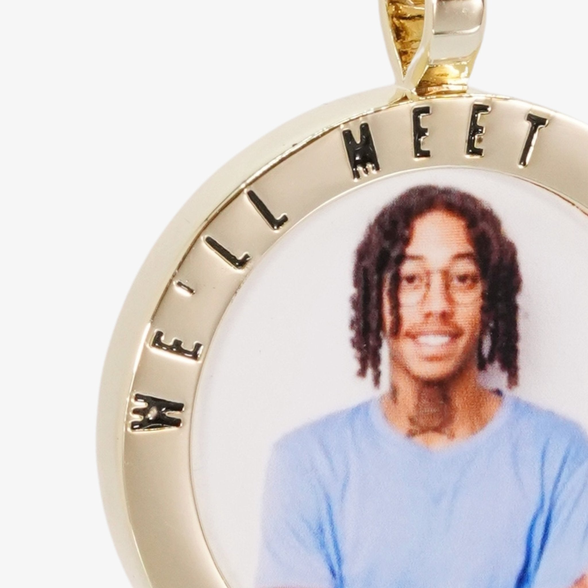 Close-up image of CRNCY's We'll Meet Again Photo Pendant. Focusing on the engraved words on the top of the photo pendant.